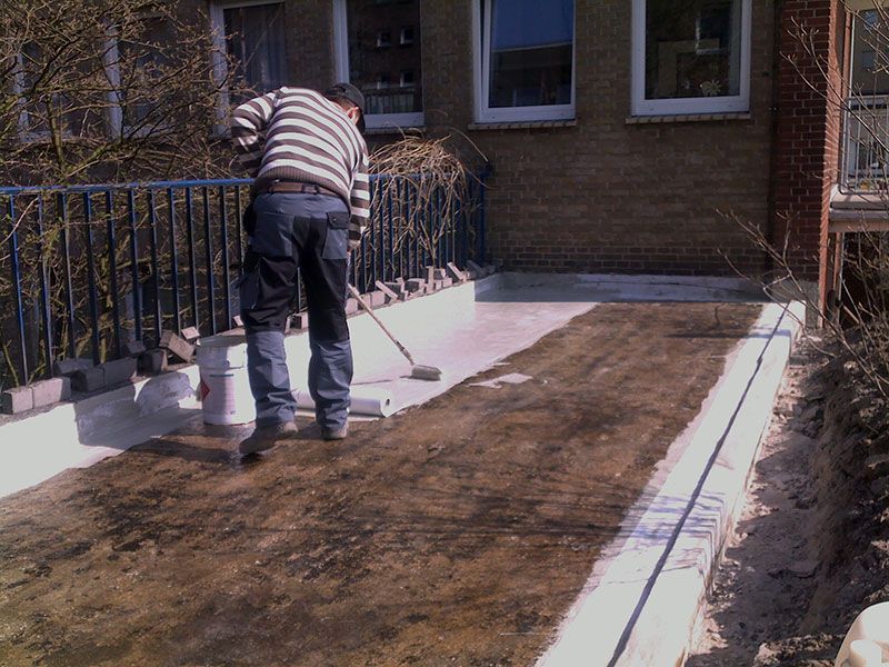 Person versiegelt fachgerecht eine Boden